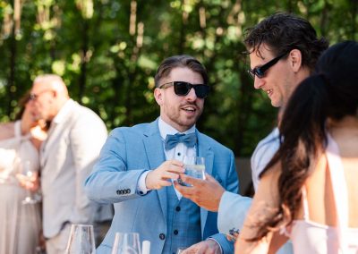 Esküvői vendégek a szabadban, elegáns ruhában, ünnepi hangulatban.