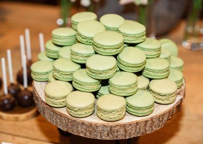 Zöld macaronok esküvői tortánál, romantikus hangulatban.