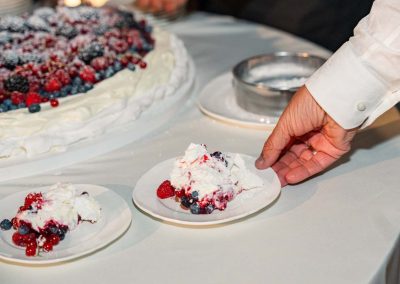 Esküvői torta szeletelése gyümölcsökkel és kézzel.