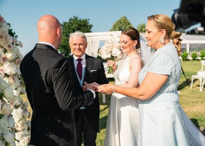 Esküvői ceremónia a szabadban, boldog pár és család jelenlétében.