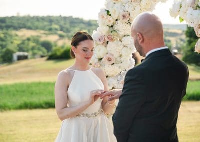 Esküvői pár az esküvői szertartáson, virágdekorációval háttérben.