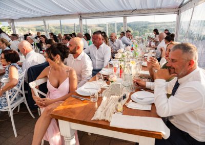 Esküvői vendégek egy elegáns asztalnál, boldog pillanatok a szertartás alatt.