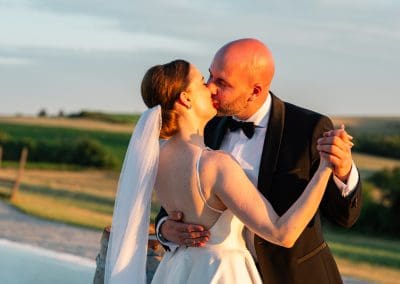 Esküvői pár csók a természetes tájban, romantikus pillanat.