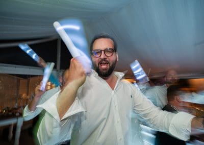 Vidám férfi esküvőn, konfetti és fények között.