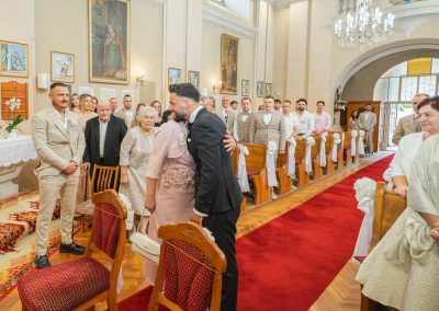 Esküvői ceremónia a templomban, vendégek és pár a szertartás alatt.
