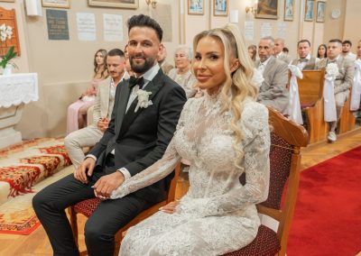 Esküvői pár a templomi esküvőn, boldog és elegáns megjelenésben.