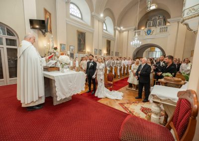 Esküvői szertartás a templomban, boldog pár és vendégek jelenlétében.