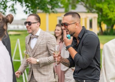 Esküvői vendégek társaságban, mosolyogva és pezsgőt kortyolgatva.