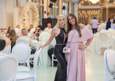 Esküvői képek, két nő a lakodalmi vacsorán, elegáns ruhában, boldog pillanatban.