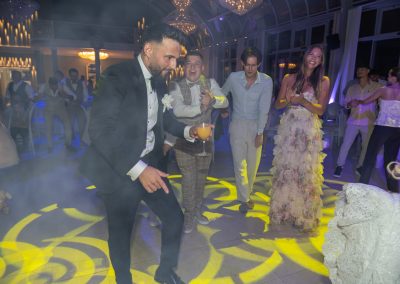 Esküvői vendégek táncolnak és szórakoznak a lagzin, elegáns ruhában.