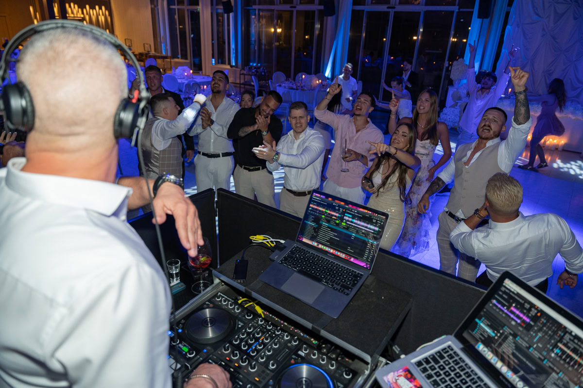 Lizi-es-David-eskuvoi-fotozas-Forgach-kastely- 674 Esküvői buli a DJ pultnál, vendégek táncolnak és szórakoznak.